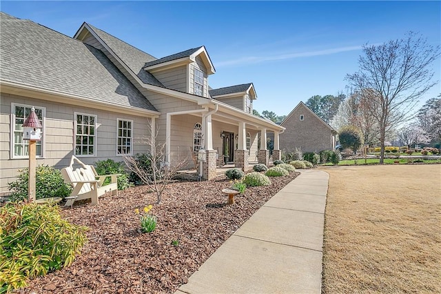 view of property exterior with a porch and roof with shingles