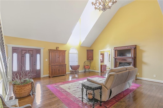 living room with baseboards, high vaulted ceiling, and hardwood / wood-style floors