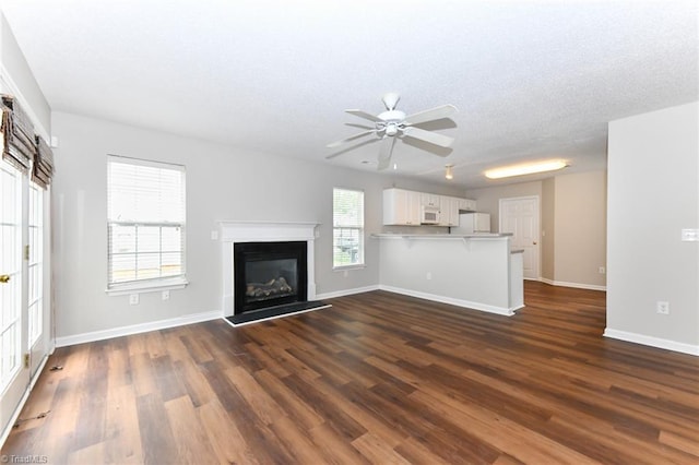 320 Apple Ridge Rd, Greensboro, NC 27406 - unfurnished living room with a ceiling fan, dark wood-style floors, a textured ceiling, baseboards, and a glass covered fireplace