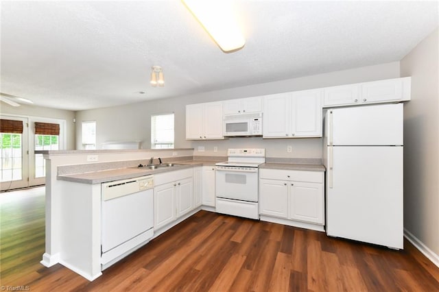 320 Apple Ridge Rd, Greensboro, NC 27406 - kitchen featuring white appliances, a sink, white cabinets, dark wood-type flooring, and a peninsula