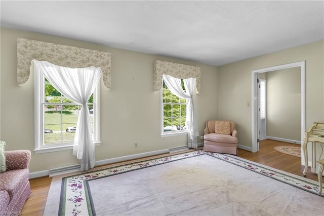 sitting room with baseboards and wood finished floors