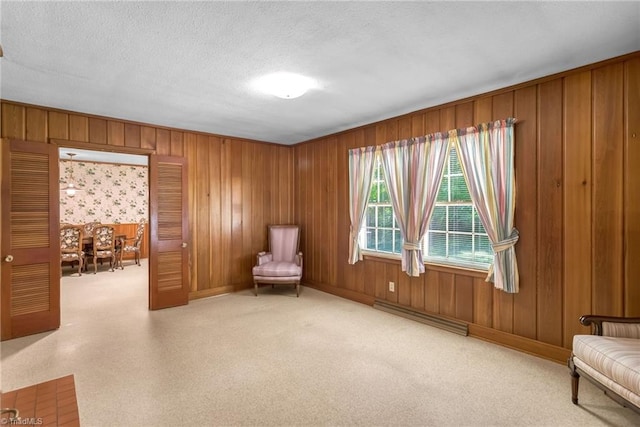 unfurnished room with wooden walls, a textured ceiling, and baseboards