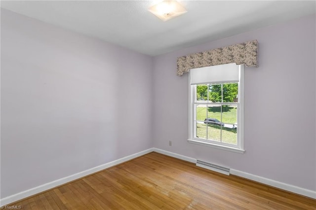 unfurnished room with baseboards, light wood-style flooring, and visible vents