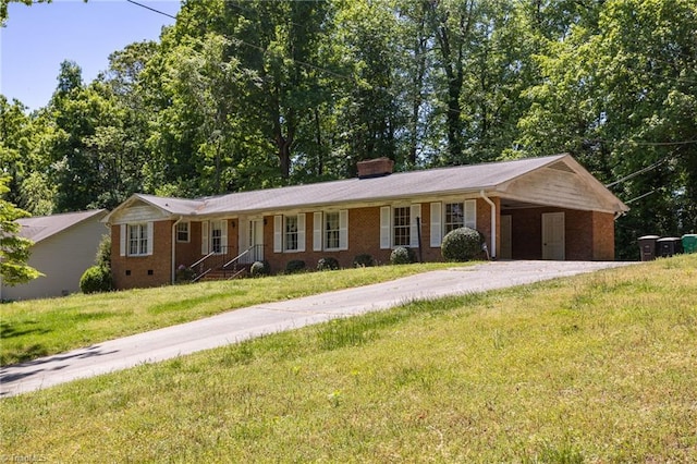 single story home featuring driveway, a chimney, brick siding, a front lawn, and an attached carport