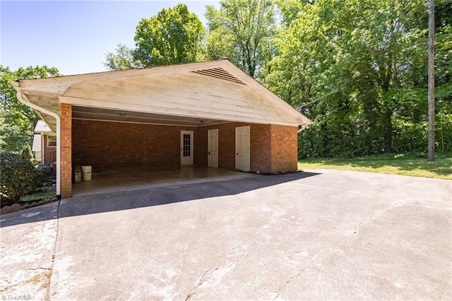 garage featuring a carport and concrete driveway