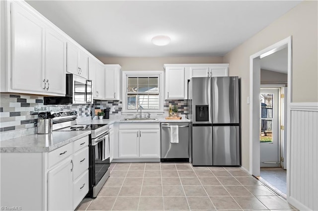 kitchen featuring white cabinetry, appliances with stainless steel finishes, sink, and light tile patterned floors