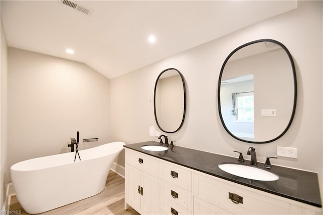 2244 US Highway 64 E, Mocksville, NC 27028 - full bath with double vanity, a freestanding tub, wood finished floors, and recessed lighting