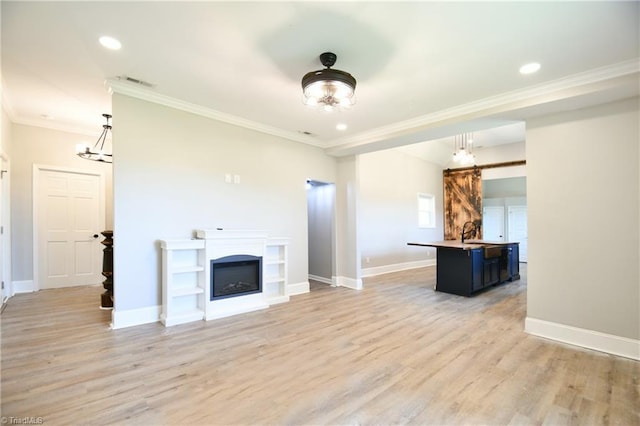 2244 US Highway 64 E, Mocksville, NC 27028 - unfurnished living room with ornamental molding, light wood-style floors, recessed lighting, and a glass covered fireplace