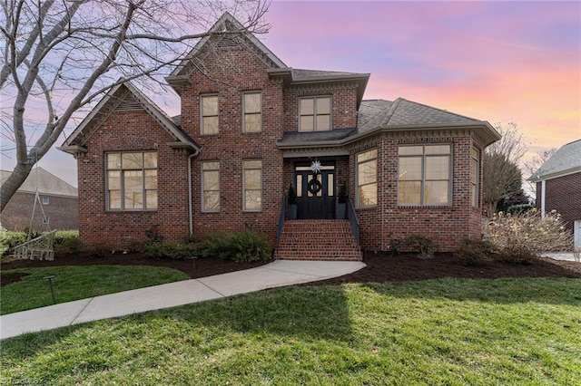 traditional-style home with brick siding and a front yard