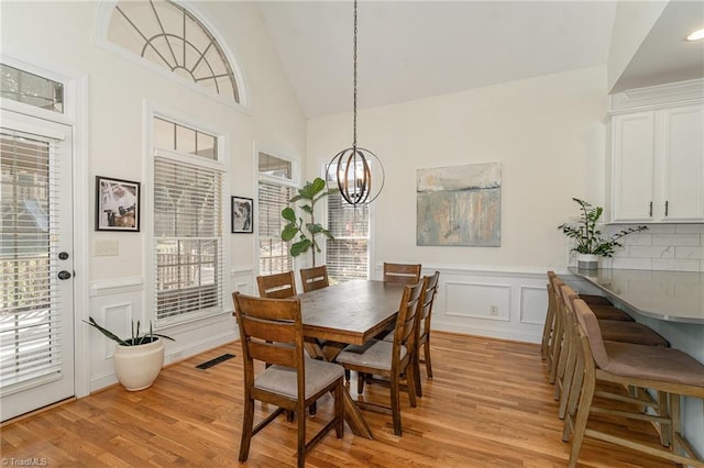 dining area with a chandelier, light wood-type flooring, visible vents, and plenty of natural light