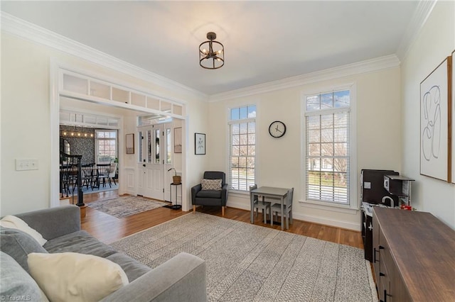 interior space with a notable chandelier, baseboards, ornamental molding, and wood finished floors