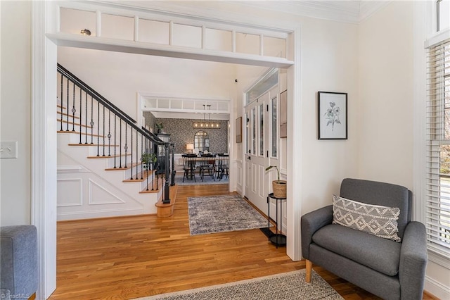 entrance foyer featuring stairway, wood finished floors, and crown molding