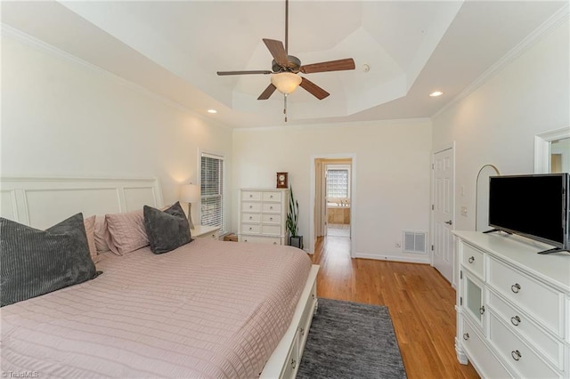 bedroom featuring visible vents, a raised ceiling, ornamental molding, light wood-style floors, and recessed lighting