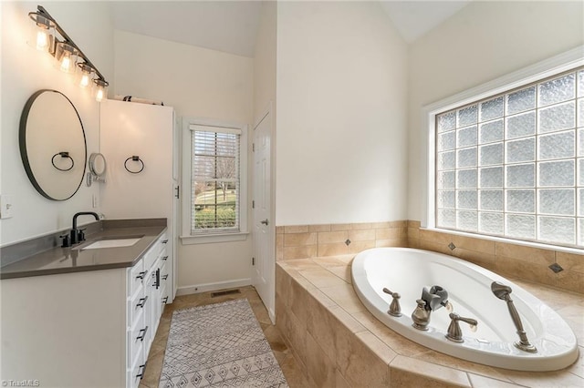 full bathroom with visible vents, tile patterned floors, vaulted ceiling, vanity, and a bath