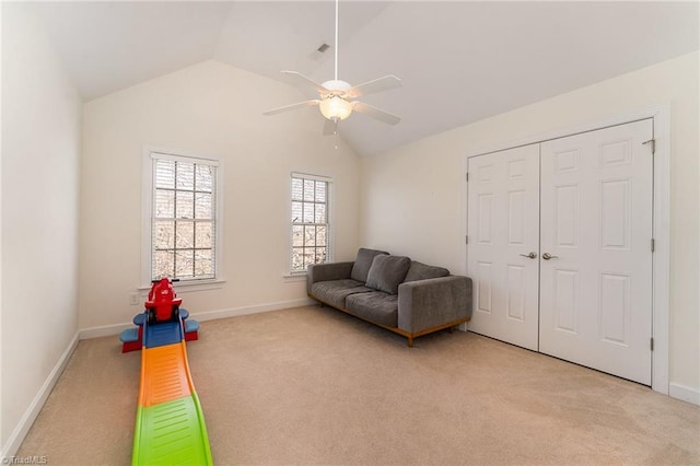 living area featuring vaulted ceiling, baseboards, a ceiling fan, and light colored carpet