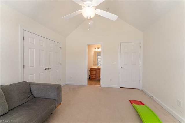 interior space featuring ceiling fan, baseboards, vaulted ceiling, and light colored carpet