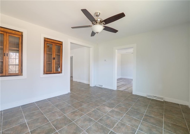 1473 Briarcliff Dr, Asheboro, NC 27205 - unfurnished room with dark tile patterned flooring, a ceiling fan, visible vents, and baseboards