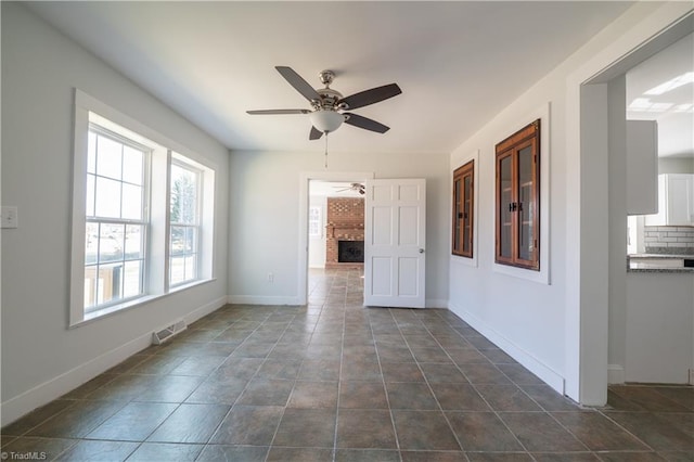 1473 Briarcliff Dr, Asheboro, NC 27205 - spare room featuring a fireplace, a ceiling fan, visible vents, and baseboards