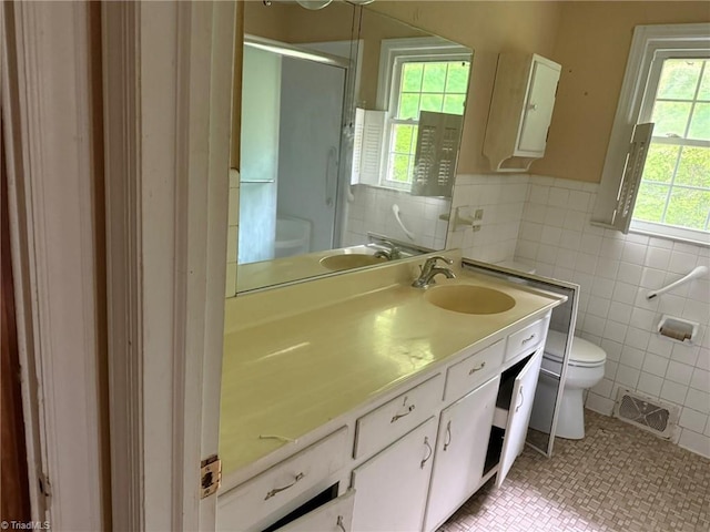 615 Paris St, Graham, NC 27253 - full bath with visible vents, tile walls, toilet, a shower stall, and vanity