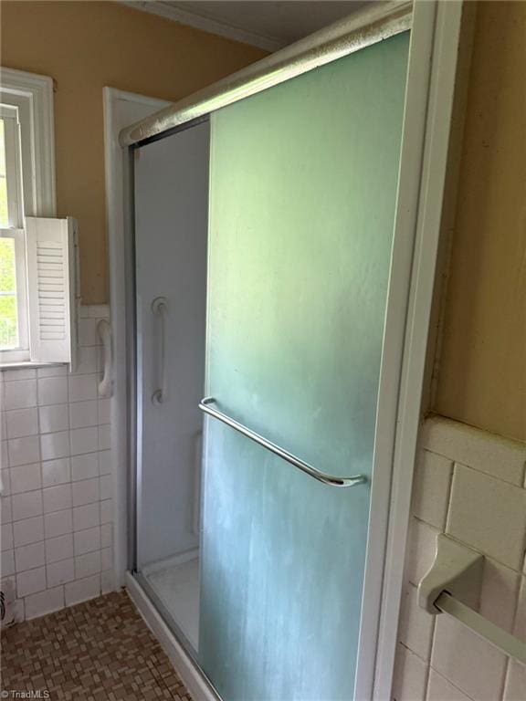615 Paris St, Graham, NC 27253 - full bathroom with tile walls, a stall shower, and wainscoting