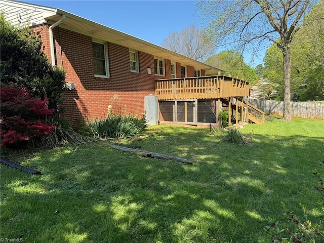 615 Paris St, Graham, NC 27253 - rear view of property with stairway, brick siding, a wooden deck, fence, and a lawn