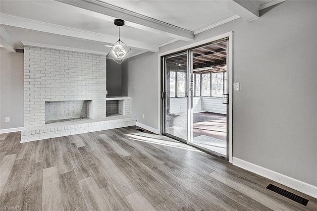 unfurnished living room with a fireplace, beam ceiling, ornamental molding, and hardwood / wood-style floors