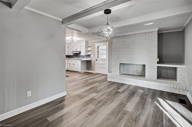 unfurnished living room with light wood-type flooring, a brick fireplace, and crown molding