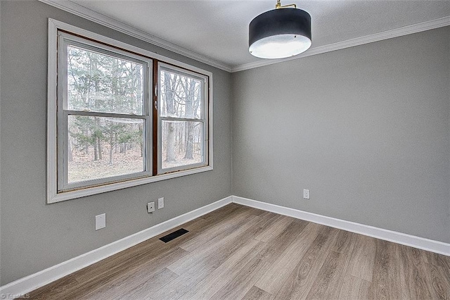 empty room with crown molding and hardwood / wood-style flooring