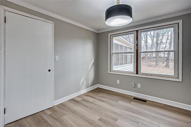 spare room with ornamental molding and light hardwood / wood-style floors