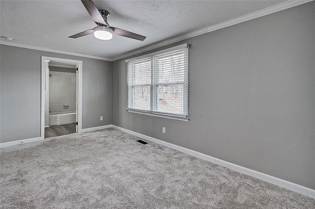 empty room featuring ceiling fan, light colored carpet, crown molding, and a textured ceiling