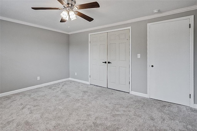 unfurnished bedroom with ceiling fan, crown molding, and light colored carpet