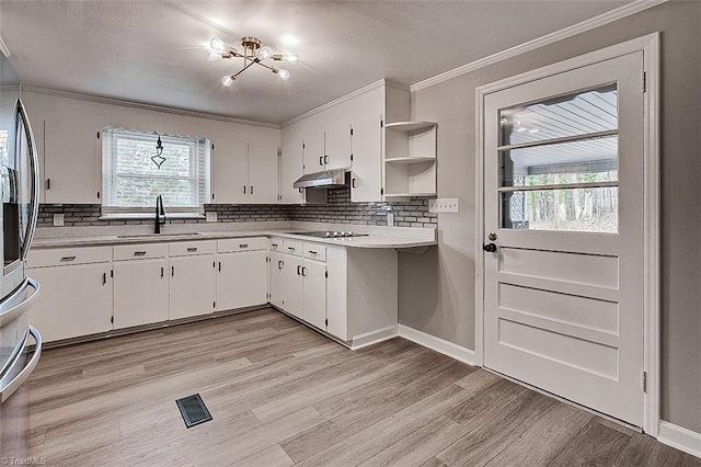 kitchen with black electric stovetop, white cabinetry, a healthy amount of sunlight, and sink