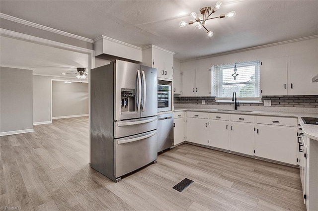 kitchen featuring sink, stainless steel appliances, white cabinetry, and ceiling fan with notable chandelier