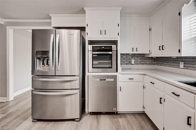 kitchen with white cabinetry, ornamental molding, and appliances with stainless steel finishes