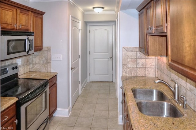 kitchen with ornamental molding, decorative backsplash, appliances with stainless steel finishes, brown cabinetry, and a sink