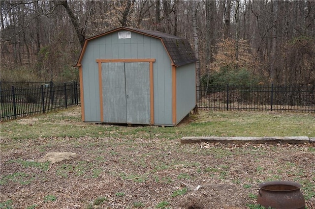 view of shed with a forest view and a fenced backyard