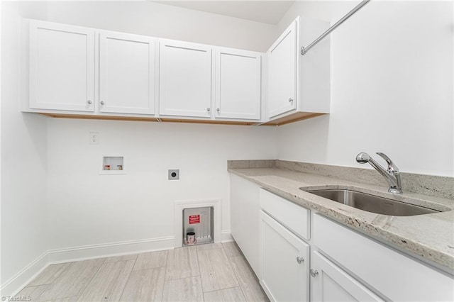 washroom featuring washer hookup, a sink, cabinet space, baseboards, and hookup for an electric dryer