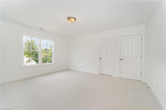 carpeted spare room featuring crown molding