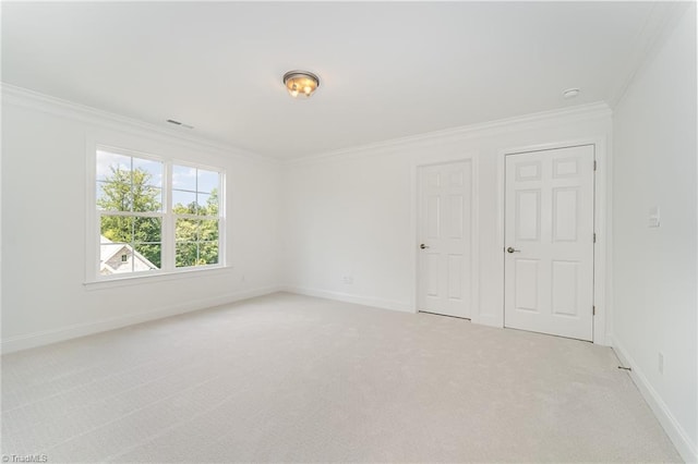 unfurnished bedroom with light colored carpet, crown molding, and baseboards