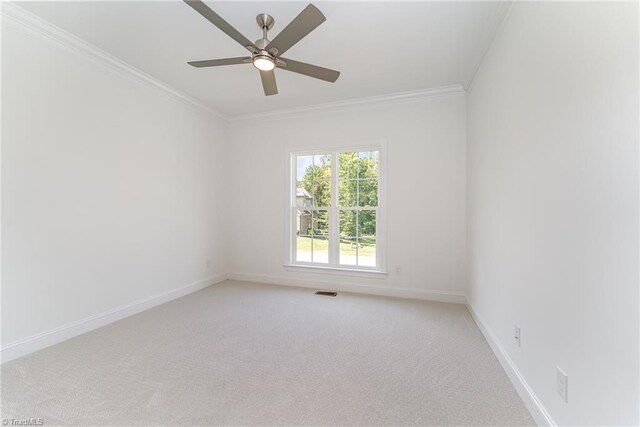 carpeted empty room featuring ceiling fan and ornamental molding