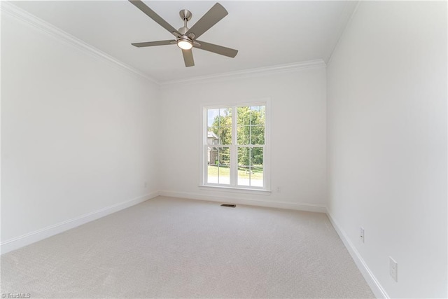 spare room with visible vents, a ceiling fan, crown molding, baseboards, and light colored carpet
