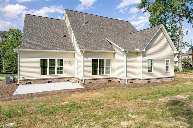 rear view of house featuring a shingled roof, a patio, a yard, and crawl space