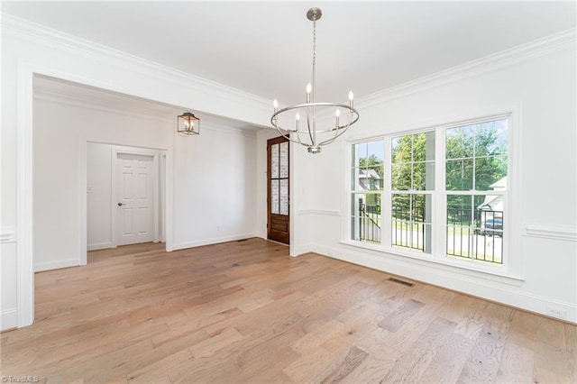 unfurnished dining area with baseboards, visible vents, light wood-style flooring, crown molding, and a notable chandelier