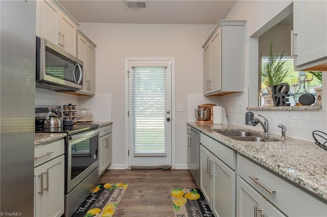 1272 Adrian Ct, Mebane, NC 27302 - kitchen with stainless steel appliances, a sink, decorative backsplash, dark wood-style floors, and light stone countertops