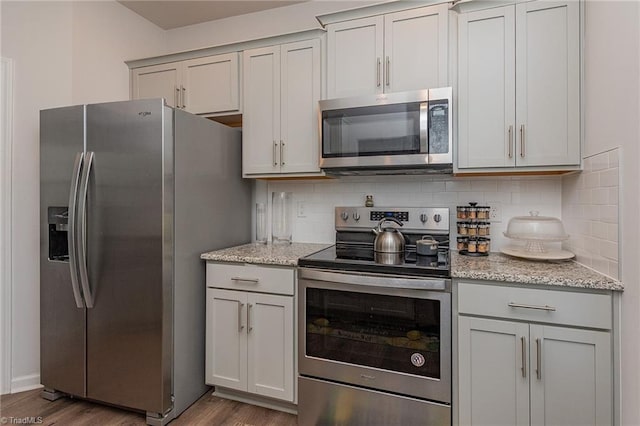 1272 Adrian Ct, Mebane, NC 27302 - kitchen featuring appliances with stainless steel finishes, wood finished floors, backsplash, and light stone countertops