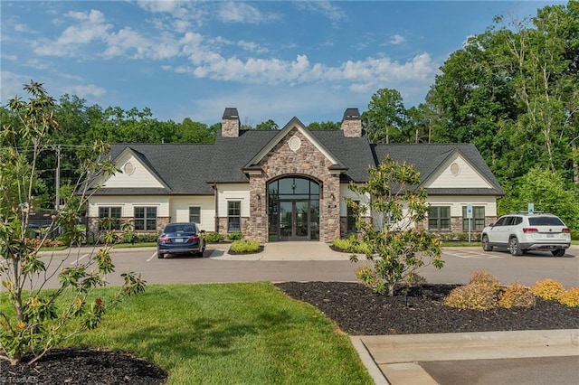1272 Adrian Ct, Mebane, NC 27302 - view of front of house with stone siding, a chimney, french doors, and a front lawn