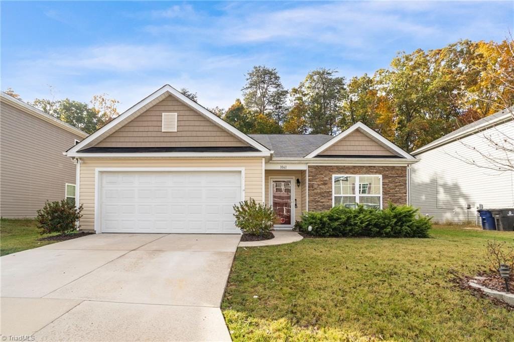 view of front of home with a front yard and a garage