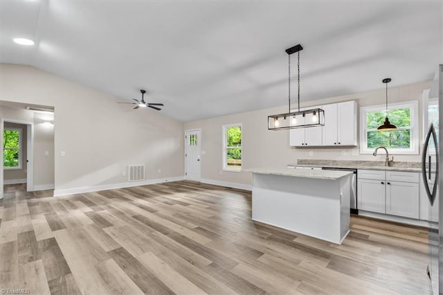 3077 Little Creek Dr, Thomasville, NC 27360 - kitchen featuring vaulted ceiling, stainless steel appliances, white cabinetry, light wood-style flooring, and hanging light fixtures