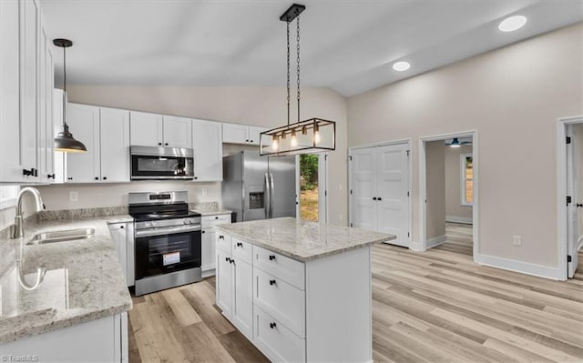 3077 Little Creek Dr, Thomasville, NC 27360 - kitchen featuring stainless steel appliances, vaulted ceiling, white cabinetry, light wood finished floors, and decorative light fixtures