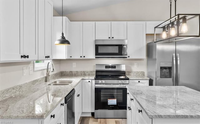 3077 Little Creek Dr, Thomasville, NC 27360 - kitchen featuring appliances with stainless steel finishes, light wood-type flooring, white cabinetry, vaulted ceiling, and a center island